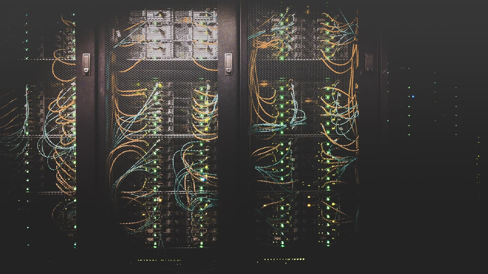 Server racks wired with green and amber cables