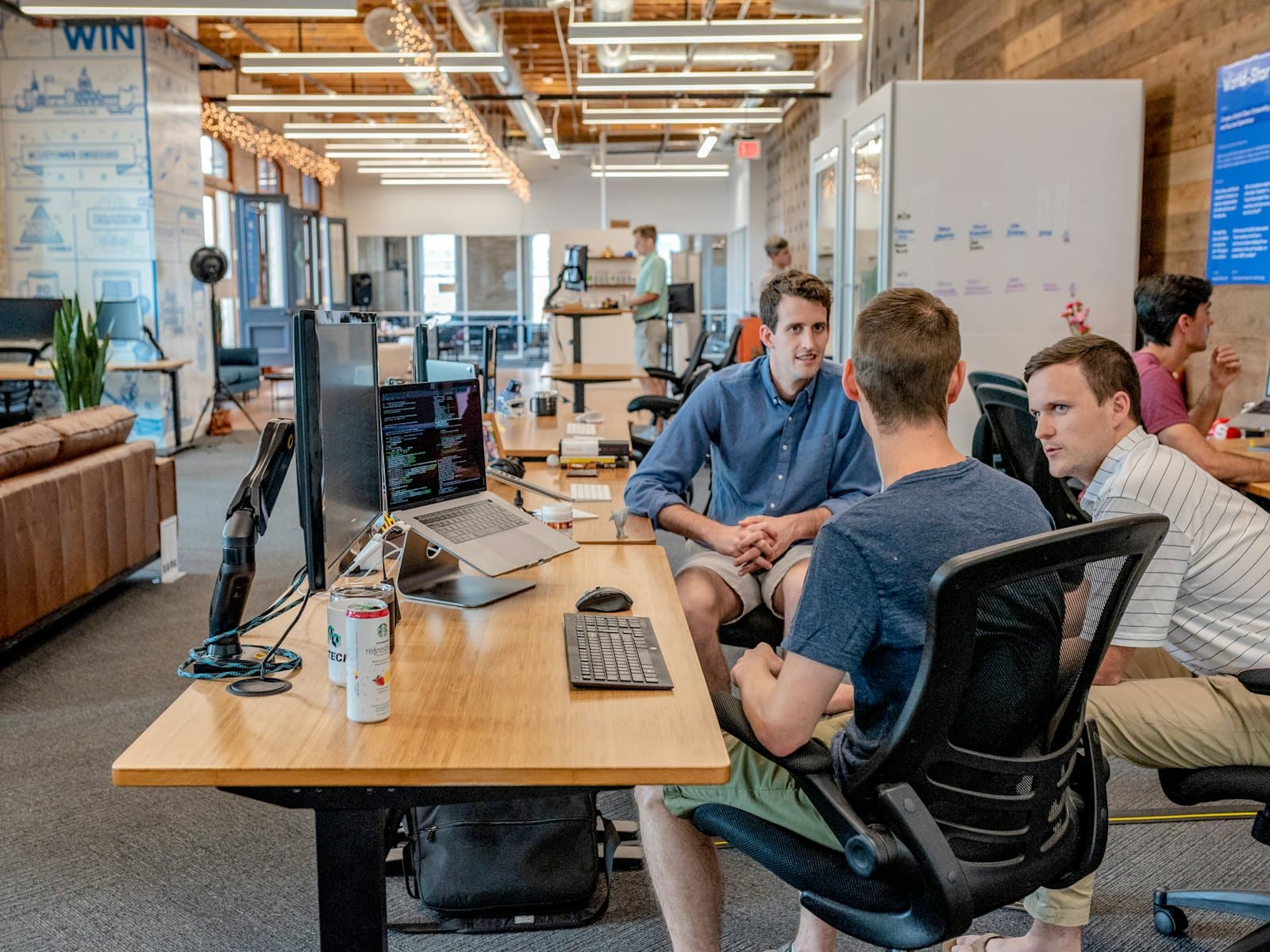 Colleagues in discussion at a desk in a bright office