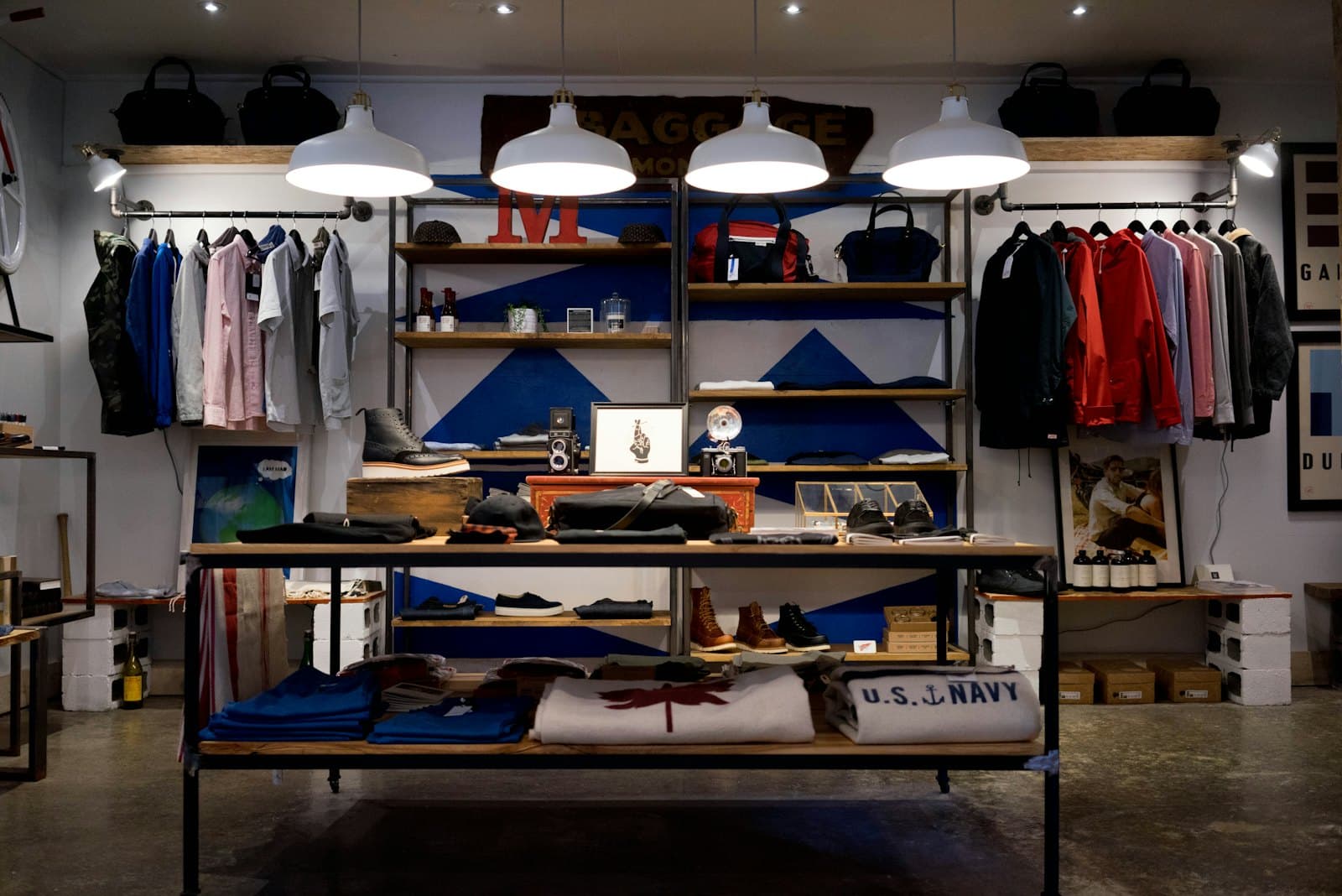 A clothing boutique with racked apparel and a maple-leaf blanket on the front table